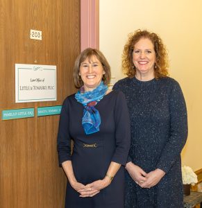 Pam Little and Nancy Tomasko standing outside of their office front door